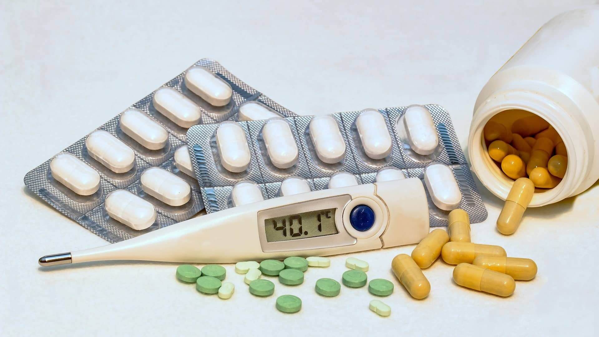 Fieberthermometer und Medikamente auf einem Haufen