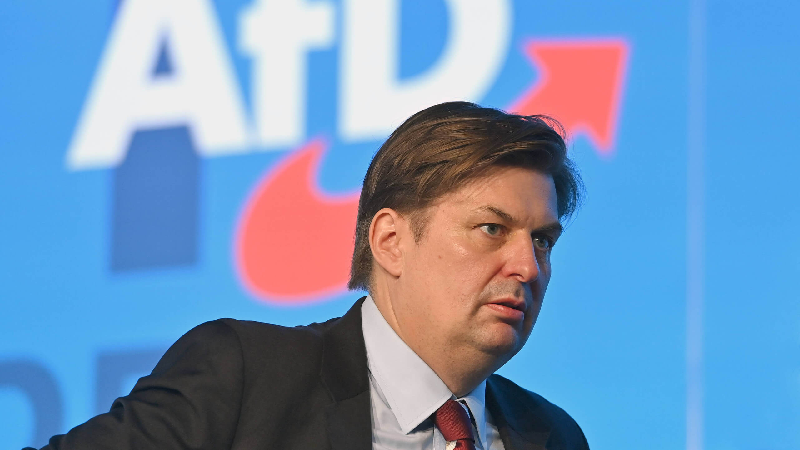 Maximilian Krah vor dem AfD Logo